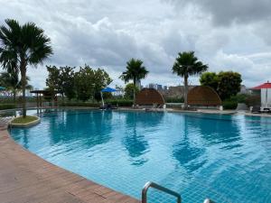 努沙再也GS home的一个种有棕榈树的大型蓝色游泳池