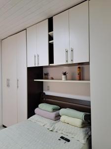 萨尔瓦多Vilage Taipan 02 - Praia Stella Maris的卧室配有白色橱柜和1张带毛巾的床。