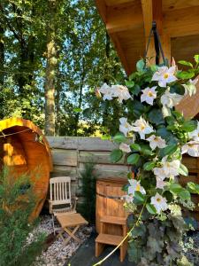 皮滕CHALET HARMONY prive WELLNESS的花园设有木舱,带长凳和鲜花