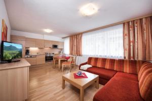 弗拉绍萨尔茨堡贺夫公寓的一间带红色沙发的客厅和一间厨房