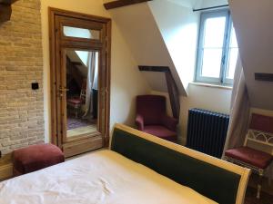圣奥梅尔CLOS DU BAILLI的一间卧室配有一张床、两把椅子和一个窗户
