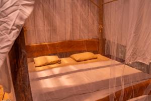 伊基托斯Family hotel PURMA CASPI on the jungle lake的一张小床,上面有两个枕头