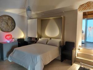 菲亚诺Dimora Rosso 27的一间卧室配有一张床、一个钟和一把椅子