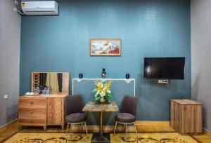 巴库Prestige Boutique Hotel的一间设有一张桌子和一台电视的蓝色墙壁客房