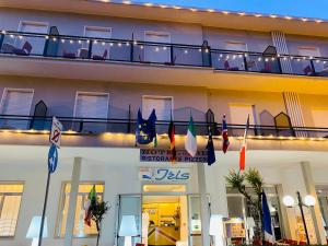 里米尼hotel iris的酒店外设有带旗帜的阳台