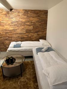 斯塔万格A Place To Stay Stavanger, apartment 1的一张桌子和砖墙的房间里设有两张床