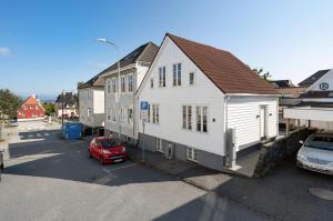 斯塔万格A Place To Stay Stavanger, apartment 1的停车场里的一个白色房子,有一辆红色的汽车