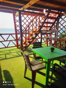 布兰卡滩Posada chikiluky beach的海洋门廊上的绿色桌椅