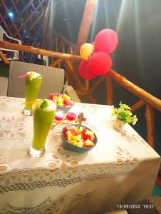 布兰卡滩Posada chikiluky beach的一张桌子,上面放着两碗水果和饮料
