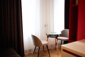 久姆里BARBAR APART HOTEL的客房设有桌子、两把椅子和窗户。