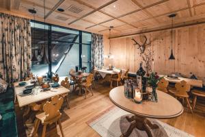 沃瑟姆阿尔伯格LUX ALP CHALET am Arlberg的餐厅拥有木墙和桌椅