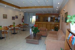 Agia ErmioniSunrise Hotel的客厅配有沙发和桌子