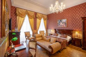 卢切内茨Galicia Nueva, castle hotel的一间卧室配有一张床、一张沙发和一个吊灯。