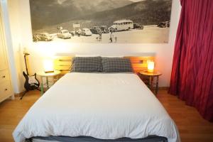 塞尔塞迪利亚Loft Puerto de Navacerrada的一间卧室配有一张大床、两张桌子和两盏灯。