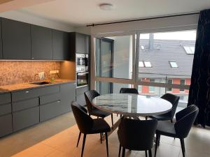陶努斯山麓霍夫海姆Valley of Business Frankfurt-West - Penthouse Nº1 - Three-Bedroom的厨房配有桌椅和窗户。