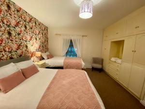 德拉姆尚博Canice Mooney Self Catering Holiday Home的一间卧室设有两张床和窗户。