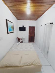 博阿维斯塔Suíte agradável no centro da cidade.的一间卧室设有一张带木制天花板的大床