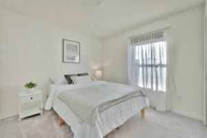 萨拉索塔Serene Sarasota Residence * By th Beach & Airport!的白色的卧室设有白色的床和窗户。