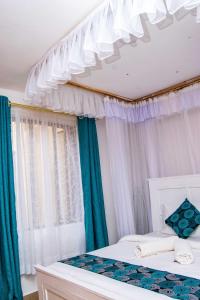 基苏木Tina's 1 BR Apartment with Fast Wi-Fi, Parking and Netflix - Kisumu的一间卧室配有两张带蓝白色窗帘的床