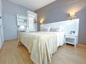 埃斯特角城米兰酒店的一间卧室配有一张带白色床罩的大床