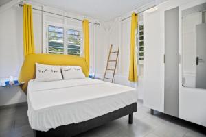 Saint-JosephLe Havre Vert avec Piscine et Evènements autorisés的一间卧室配有一张床和一个黄色床头板