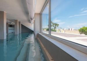 卡奥莱Unico Hotel Caorle的一座带窗户的建筑的一侧的游泳池