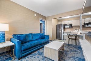 土桑3 Palms Tucson North Foothills的一间带蓝色沙发的客厅和一间厨房