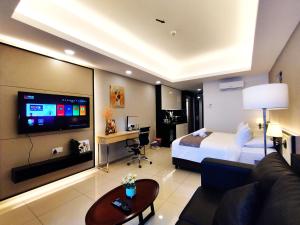 云顶高原TopGenting RetreatColdSuite4Pax @GrdIonDelmn的大型酒店客房设有一张床和一台电视机