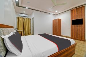BhutiāgāonCollection O The Grand Megha Resort的卧室配有一张床,墙上配有电视。