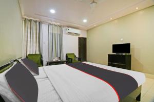 BhutiāgāonCollection O The Grand Megha Resort的酒店客房,配有床和电视