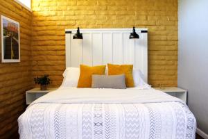 塞多纳The Three Keys duplex的卧室配有带橙色枕头的大型白色床