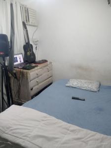 里约热内卢Rocinha House的一间卧室配有一张床和一个带吉他梳妆台。