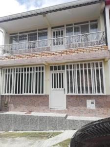 菲兰迪亚Casa de Ensueño en Filandia: Tu Hogar Lejos de Casa的白色门和阳台的房子