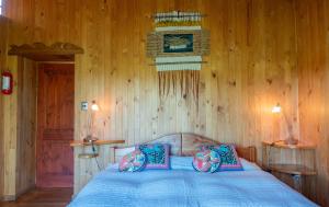奥克泰港Zapato Amarillo Bed & Breakfast的一间卧室配有蓝色的床和木墙