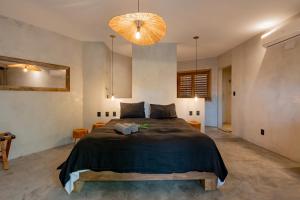 杰里科科拉Villa Mango Jeri的一间卧室配有一张大床和一个吊灯。