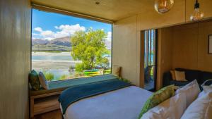 格莱诺基生态风景酒店的一间卧室设有大窗户,享有水景