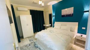 开罗Cozy apartment in down town的卧室配有白色床和蓝色墙壁