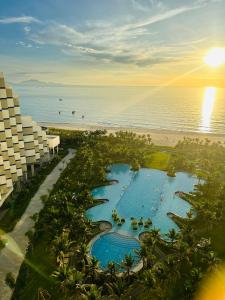 Miếu ÔngThe Arena Cam Ranh Resort all Luxury Service的享有度假村游泳池和海滩的空中景致