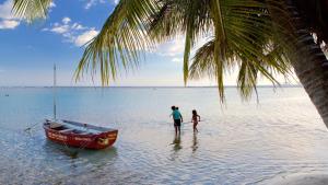 博卡奇卡Confortable apto. en Boca Chica的两个人站在船边的水面上