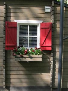 Skulte夏日度假屋的窗户,窗箱里装有红色百叶窗和鲜花