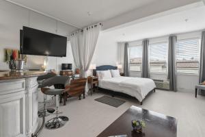 棕榈滩ORCHID SUITES - Historic Palm Beach Hotel Condominium的酒店客房带一张床铺、一张书桌和一间卧室