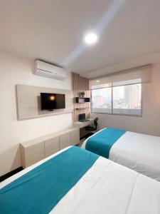 巴兰基亚Atlantis Suites Bquilla -Apartamento Moderno-2-BD的一间酒店客房,设有两张床和电视