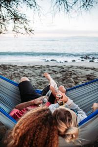 卡胡卢伊Zazu Campers的两名女孩躺在海滩上的吊床上
