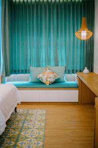 坎古Casa Amarta - Canggu的一间卧室配有一张带蓝色窗帘的长凳
