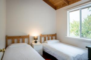 Porongurup睡美人私人木屋的带窗户的客房内的两张床