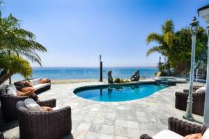 圣地亚哥Private Beach front 4bed 4bath pool and spa house的一个带椅子的游泳池,背景是大海