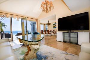 圣地亚哥Private Beach front 4bed 4bath pool and spa house的客厅配有玻璃桌和平面电视。