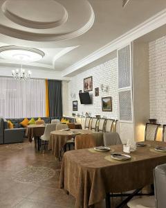 阿克托比Tanzharyk Hotel的用餐室配有桌椅和沙发