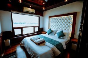 阿勒皮Why Not Houseboat的一间卧室设有一张大床和大窗户