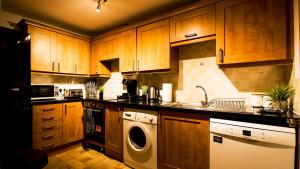 南安普敦SOUTHAMPTON Central Apartments - Wise Stays的厨房配有木制橱柜、洗衣机和烘干机